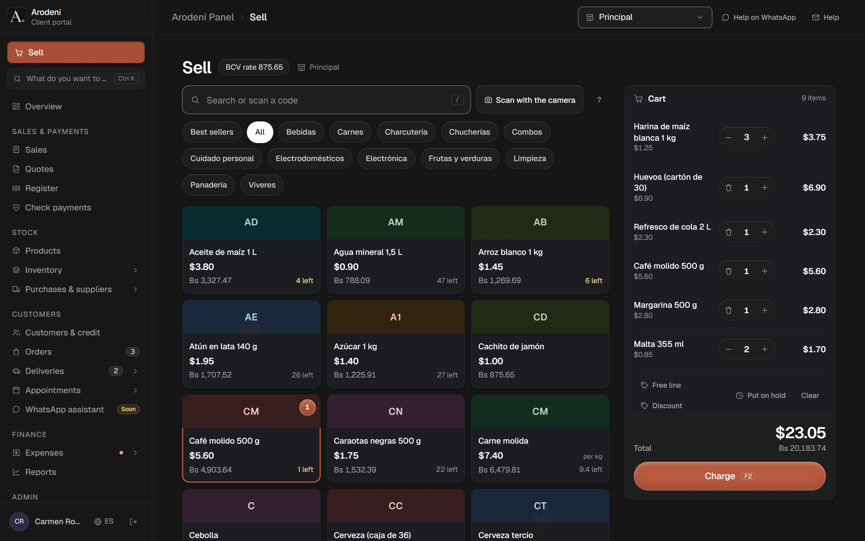 The point of sale with a grid of products priced in dollars and bolívares, and a cart with nine items